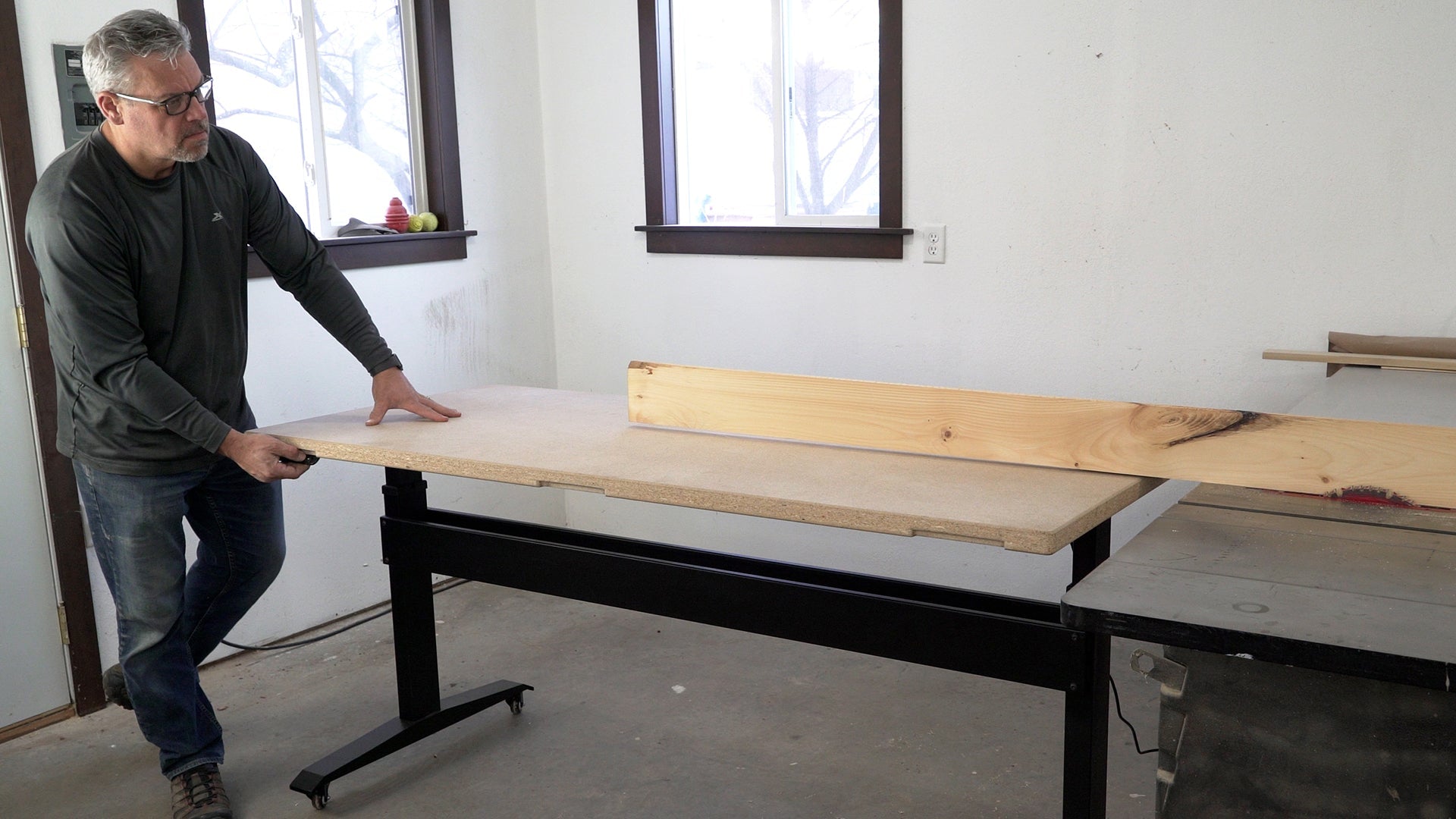 BenchBUD electric height adjustable workbench being used as outfeed table for table saw.  Front view. 