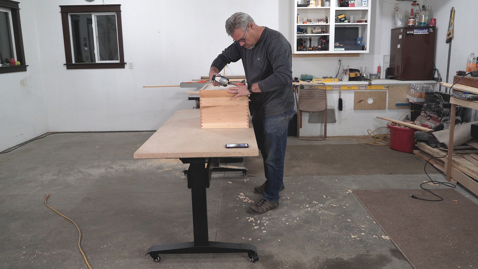 BenchBUD electric height adjustable workbench at low height so user can easily assemble his project. Showing base with top. Side view.